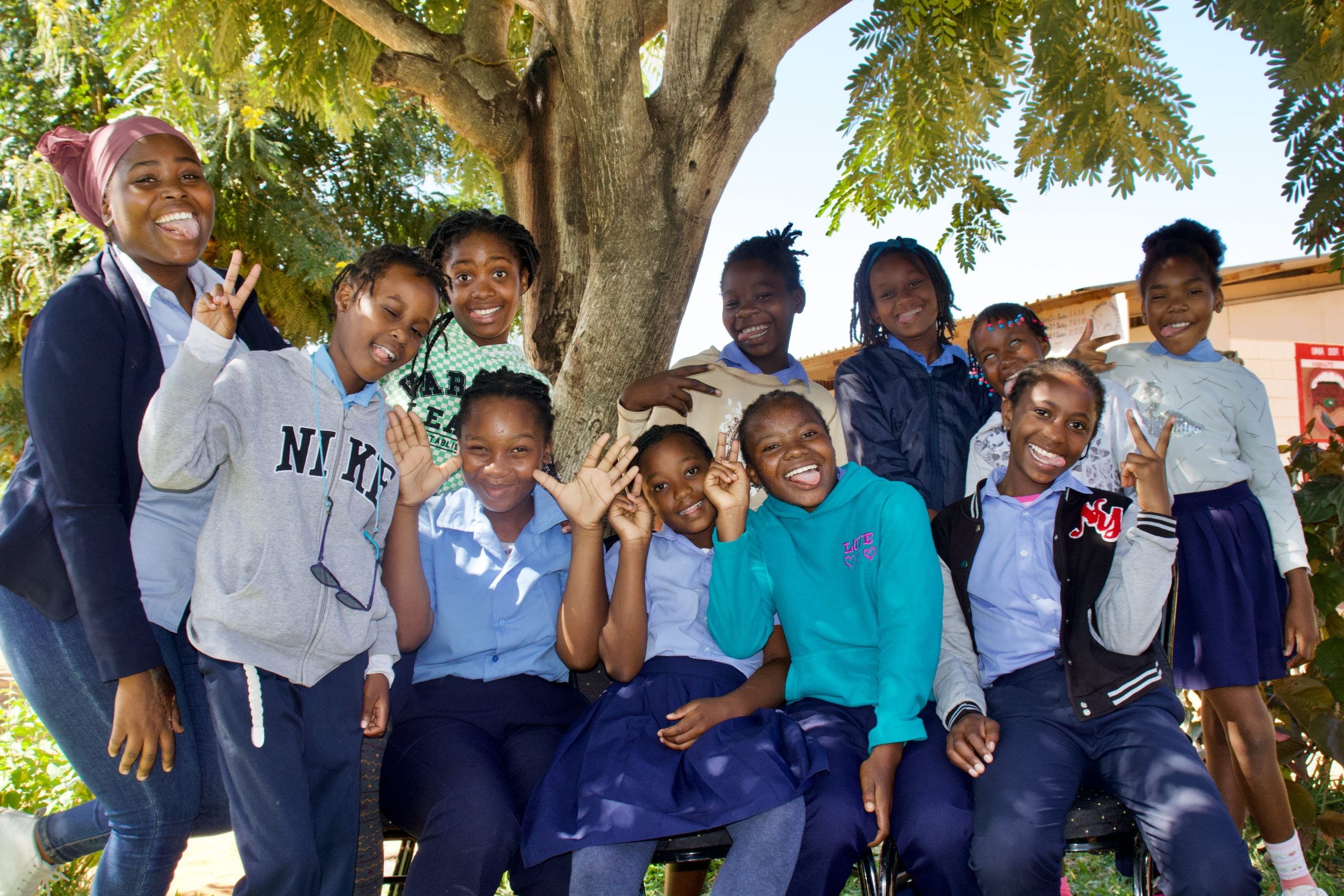 Unga tjejer i grupp skrattar och gör roliga miner.